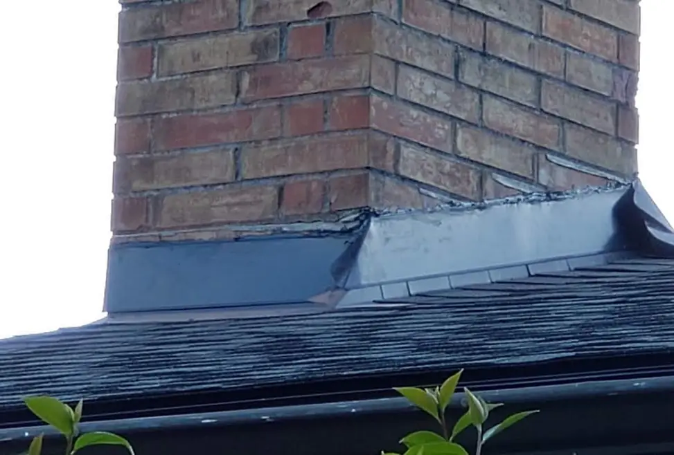 Brick chimney with new step flashing worked into the shingles