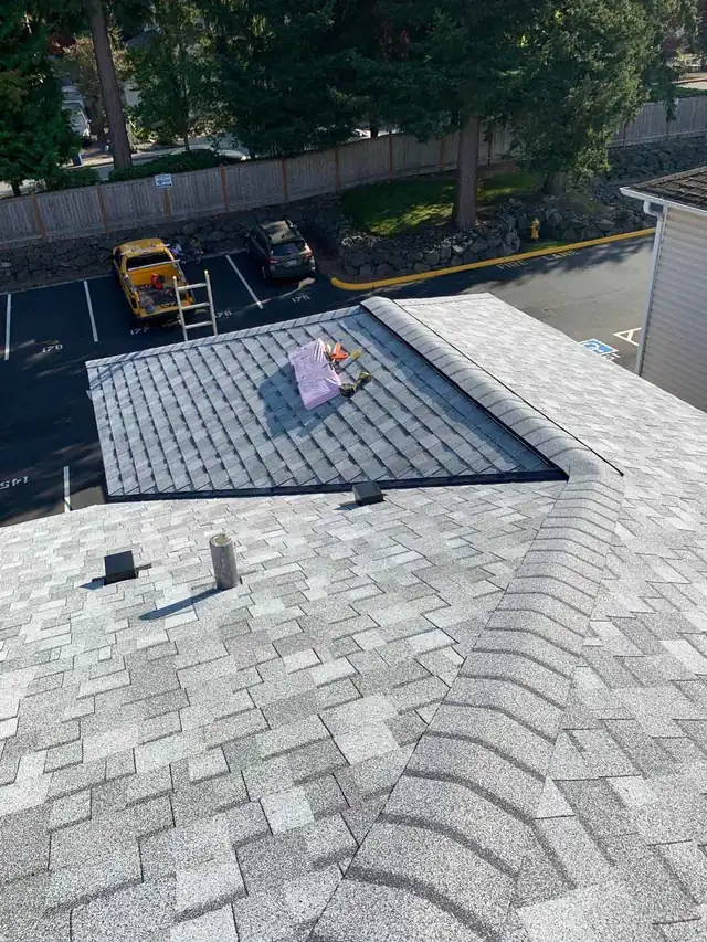 Fresh light-grey architectural shingles on a Pacific Pride re-roof, with vents and the ridge line in place